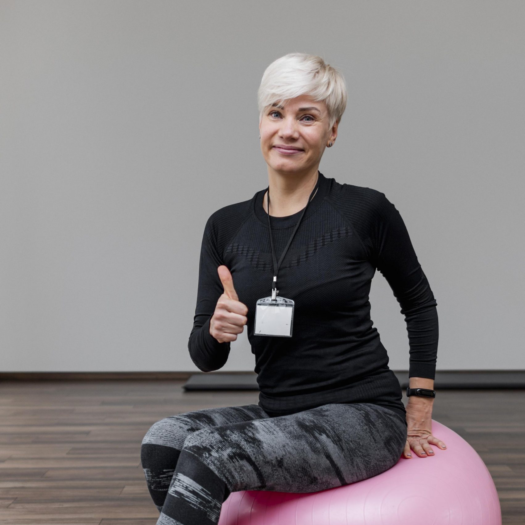 cute-personal-trainer-sitting-fitness-ball